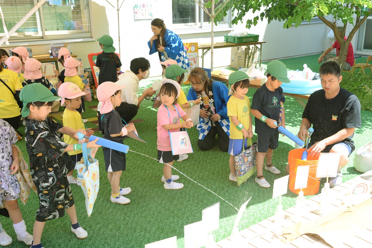 先生と輪になって過ごす子どもたち