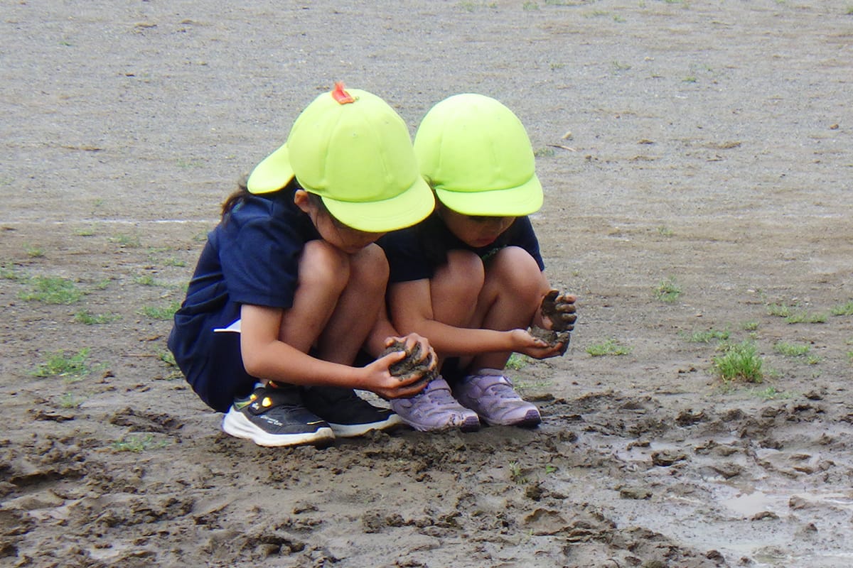 泥遊びをする園児